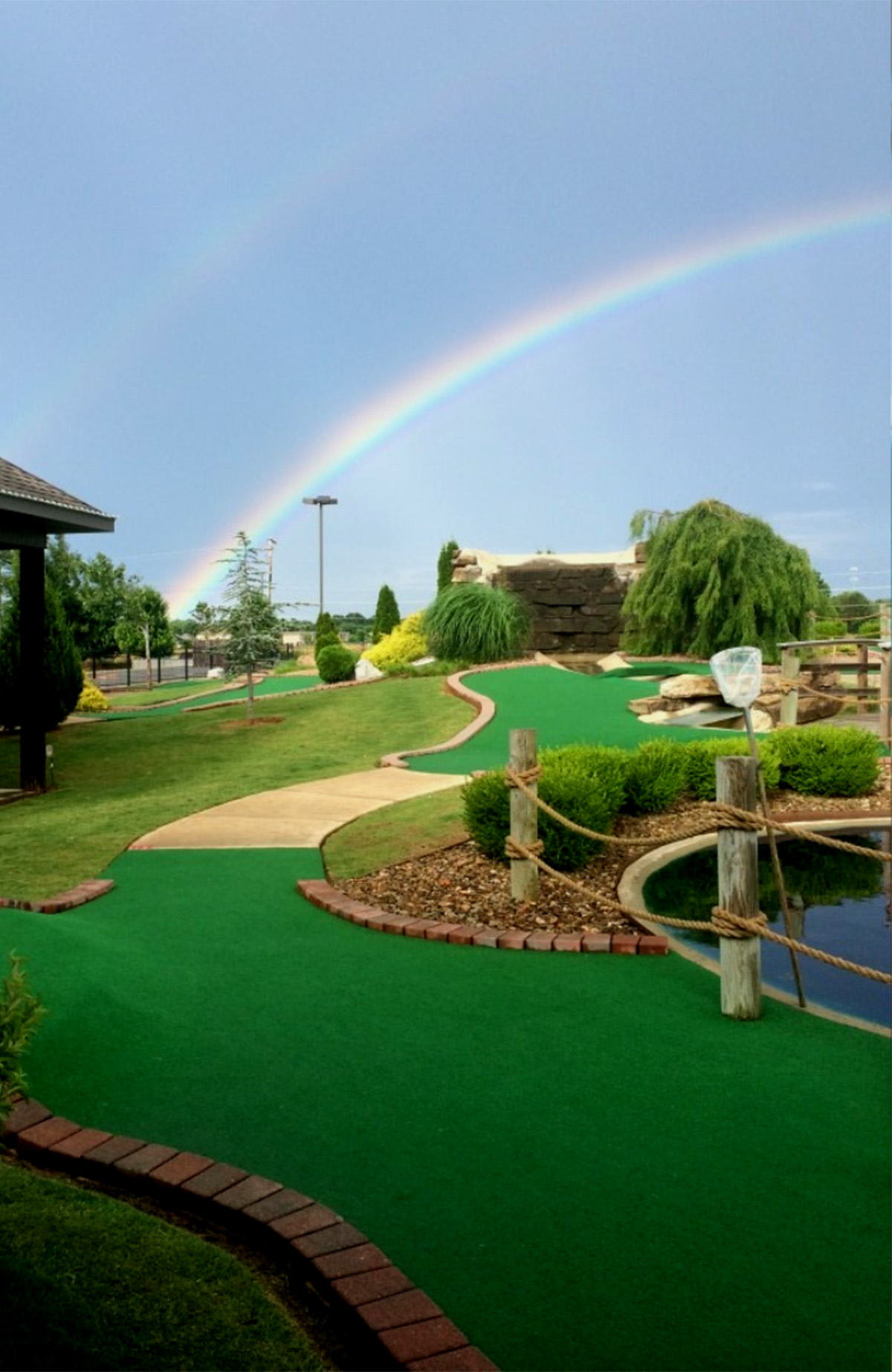 Family playing mini golf outdoors on a sunny day